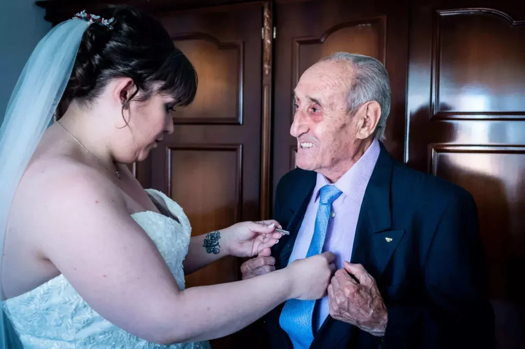 fotografo-boda-sevilla-novia-colocandole-la-corbata-a-su-abuelo